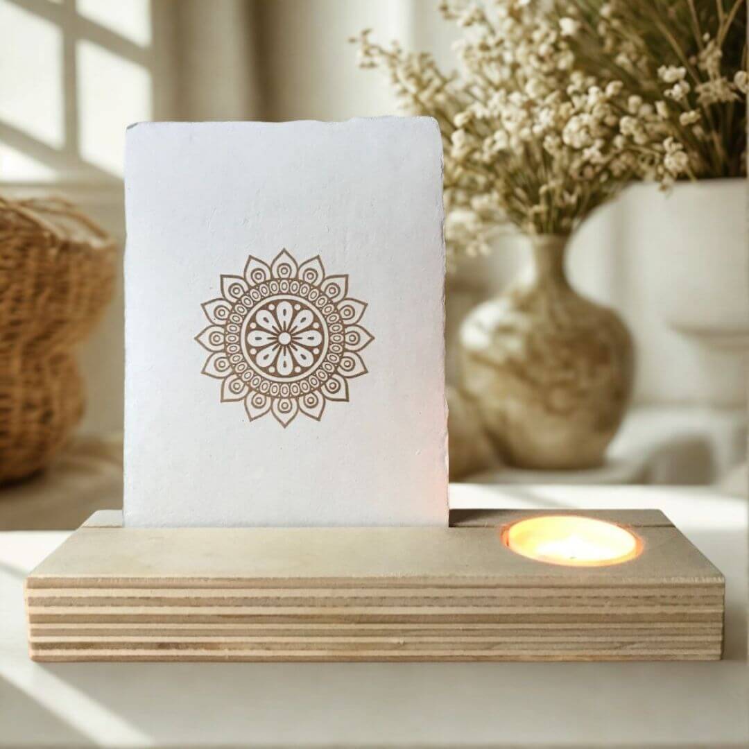 Kaartenhouder-blank-biologisch-afbreekbare-kaars (7) Blank houten kaartenhouder met brandend theelichtje en ecru kleurige kaart met scheprand en mandala zonnebloem opdruk.