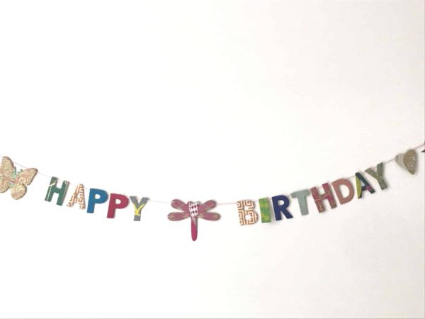 Verjaardagsslinger van handgeschept papier met happy birthday letters, vlinder, libel en hartje.