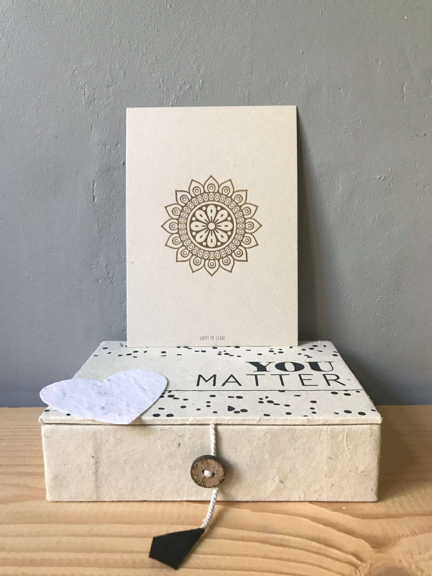 Ecru kleurig doosje van handgeschept papier met de tekst you matter, een wit hartje van groeipapier en een mandala kaart.