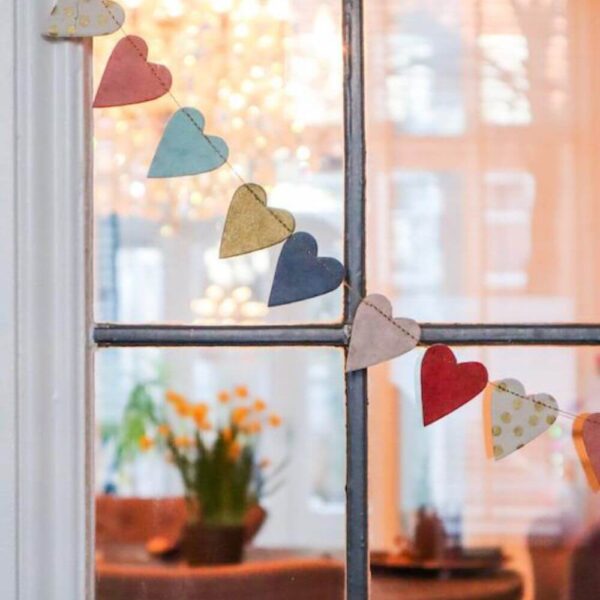 Hartjes slinger van handgeschept papier hangend voor het raam.